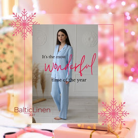 A woman wearing Baltic Linen pajamas, thinking that Christmas is the most wonderful time of the year, surrounded by light tones and festive snowflakes
