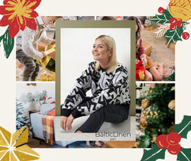 A smiling and happy woman wearing our sweater in a festive Christmas setting with gifts and holiday decorations