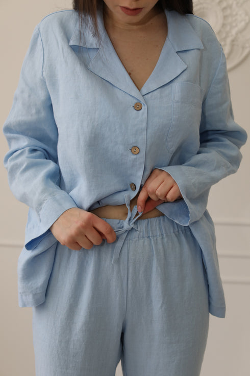 Light blue linen pyjama set formen and women, designed with a classic button-up top and matching trousers.