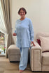 Senior lady dressed in a two-piece linen sleepwear set featuring relaxed-fit pants with elastic and a soft buttoned top.