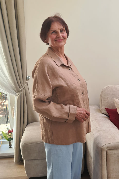 Elderly woman wearing a comfortable beige pajama jacket “KARINA” designed for seniors, featuring soft fabric, buttons, and a relaxed fit for everyday comfort.