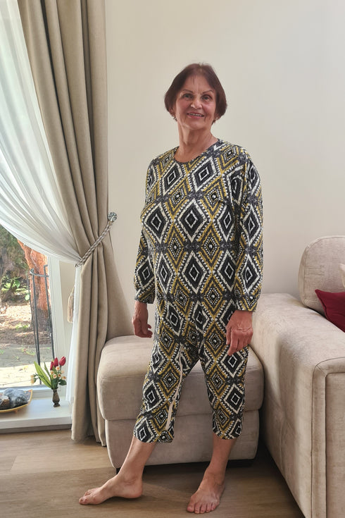 Senior lady dressed in colorful geriatric sleepwear with geometric print, offering warmth and convenience for elderly care.