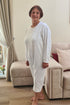 Senior lady modeling a soft, white geriatric sleepwear suit, ideal for elderly care and maximum comfort.